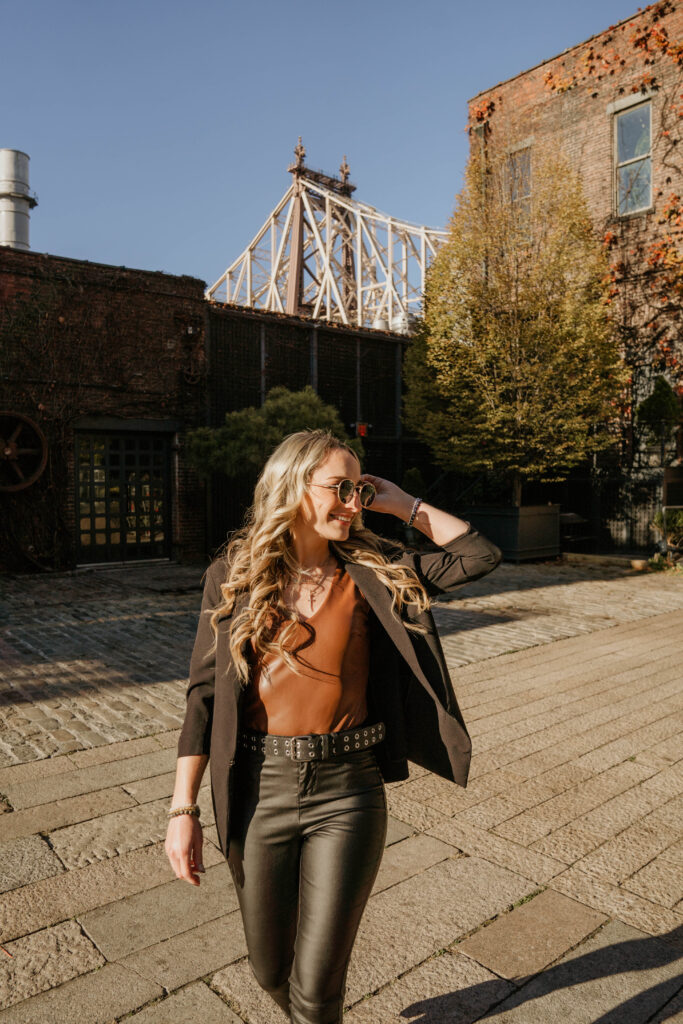Melissa from Grit & Grace Design Studio walking confidently outdoors in chic business attire, representing emotional intelligence in marketing and authentic connection through personal brand presence.